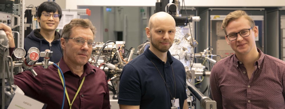 4 scientists posing for a photo in front of a beam line